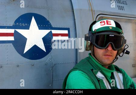 US Navy Aviation Electrician's Mate 3rd Class è in piedi osservatore di sicurezza mentre la manutenzione viene eseguita su un SH-60F Seahawk. Foto Stock