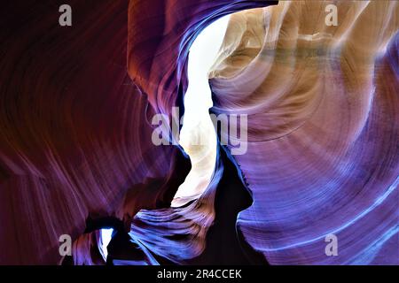 Un passaggio panoramico con rocce frastagliate sullo sfondo e un lato del passaggio illuminato da una vivace tonalità rossa Foto Stock