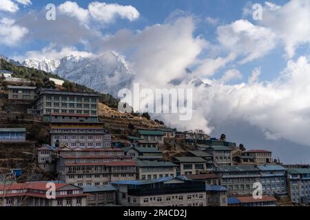 Una vista panoramica di un paesaggio collinare con diversi edifici arroccati in cima alle colline e una maestosa montagna sullo sfondo Foto Stock