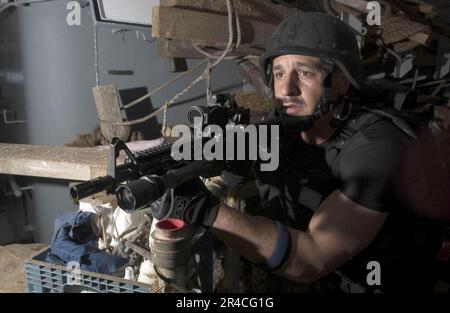 US Navy Fire Controlman 1st Classe assegnata al cacciatorpediniere missile guidato USS Hopper (DDG 70) visita, bordo, ricerca e sequestro squadra detiene una posizione durante un esercizio di imbarco non conforme Foto Stock