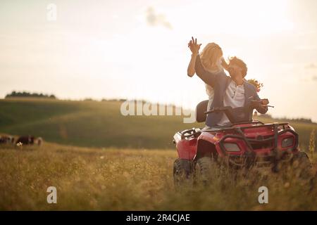Bello sposi che guidano quad insieme nella natura; concetto di matrimonio rurale Foto Stock