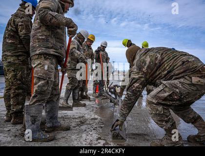 Gli airmen con il livello 114th di Squadron dell'ingegnere civile una patch da un'operazione rapida di riparazione della pista durante l'esercitazione di Lobo Trident a Hector Field, North Dakota 31 marzo 2023. Hector Field è stato creato come una stazione operativa in avanti simulata in un paese amichevole per dare ad Airmen la possibilità di praticare operazioni di emergenza in tempo di guerra e comunicazioni in una posizione remota. Foto Stock