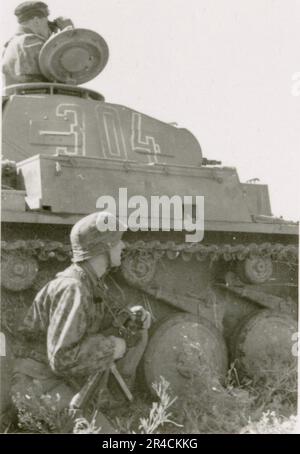 SS fotografo Willi Altstadt, Wiking Division, Russia 1942. Scene del villaggio della zona di Rostov, un Panzer III (con simboli unitari) e granatieri panzer sulla steppa, scene di combattimento lungo un fiume, primi piani della fanteria sul campo con armi individuali e servite dall'equipaggio, attraversamento del fiume (zattere d'assalto e pontone), costruzione di un blocco stradale, prigionieri di guerra russi, I soldati delle SS pescano e nuotano, cerimonia di premiazione delle unità, posto di osservazione affacciato su un fiume e equipaggio di artiglieria pesante con howitzer. Immagini che illustrano le attività in prima linea delle unità Waffen-SS sul fronte occidentale e orientale, i Foto Stock