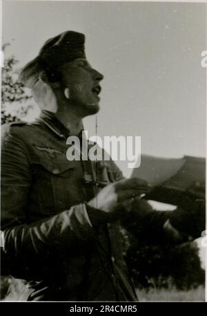 SS fotografo Willi Altstadt, Wiking Division, Russia 1942. Scene del villaggio della zona di Rostov, un Panzer III (con simboli unitari) e granatieri panzer sulla steppa, scene di combattimento lungo un fiume, primi piani della fanteria sul campo con armi individuali e servite dall'equipaggio, attraversamento del fiume (zattere d'assalto e pontone), costruzione di un blocco stradale, prigionieri di guerra russi, I soldati delle SS pescano e nuotano, cerimonia di premiazione delle unità, posto di osservazione affacciato su un fiume e equipaggio di artiglieria pesante con howitzer. Immagini che illustrano le attività in prima linea delle unità Waffen-SS sul fronte occidentale e orientale, i Foto Stock