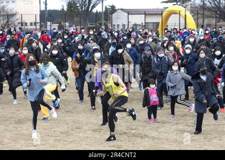 Corridori e spettatori partecipano a un riscaldamento Zumba per prepararsi alla corsa annuale di Frostbite Road 42nd alla base aerea di Yokota, Giappone, 22 gennaio 2023. Oltre 7.000 partecipanti provenienti da comunità off-base hanno partecipato a eventi fitness insieme ai membri del Team Yokota, tra cui una corsa per bambini e famiglie di 2 km, una corsa di 5 km e una mezza maratona, durante l'evento. Yokota ospita eventi della comunità come questo per contribuire a rafforzare l'amicizia e la partnership durature condivise tra gli Stati Uniti e il Giappone. Foto Stock