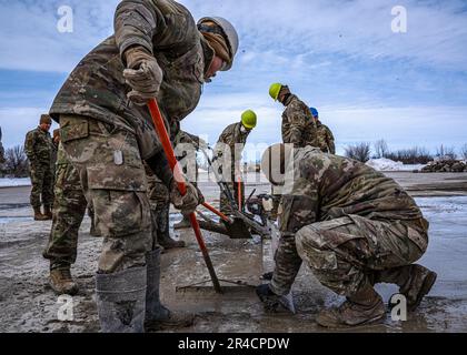 Gli airmen con il livello 114th di Squadron dell'ingegnere civile una patch da un'operazione rapida di riparazione della pista durante l'esercitazione di Lobo Trident a Hector Field, North Dakota 31 marzo 2023. Hector Field è stato creato come una stazione operativa in avanti simulata in un paese amichevole per dare ad Airmen la possibilità di praticare operazioni di emergenza in tempo di guerra e comunicazioni in una posizione remota. Foto Stock