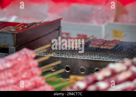 La carne spiedata viene venduta in un'edicola durante un festival. Foto Stock