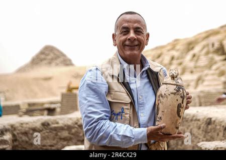 Saqqara, Egitto. 27th maggio, 2023. Mostafa Waziri, capo del Consiglio Supremo delle Antichità egiziano, ha un vaso rituale usato per la mummificazione durante l'annuncio della scoperta di due laboratori di embalming umani e animali, così come due tombe nella necropoli di Saqara. Credit: Ziad Ahmed/dpa/Alamy Live News Foto Stock