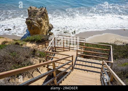 Una scalinata deserta che conduce a una spiaggia di sabbia appartata sulla costa californiana in una soleggiata giornata autunnale Foto Stock
