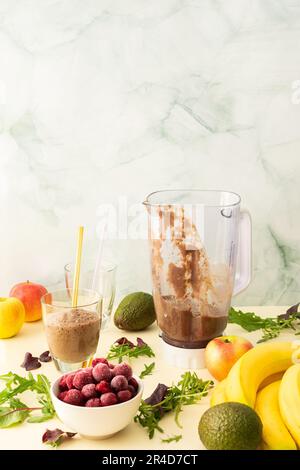 Colazioni salutari, frullati salutari e deliziosi con ciliegie e banane surgelate e avocado, proteine della piselli e verdure miste, frullato bicchiere mixer Foto Stock