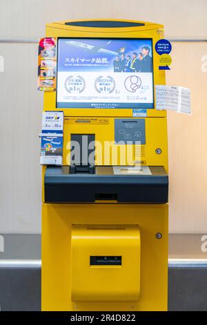 Primo piano di una macchina automatica con carta d'imbarco gialla OKI giapponese con schermo sul terminal nazionale 1 dell'aeroporto Haneda di Tokyo. Foto Stock