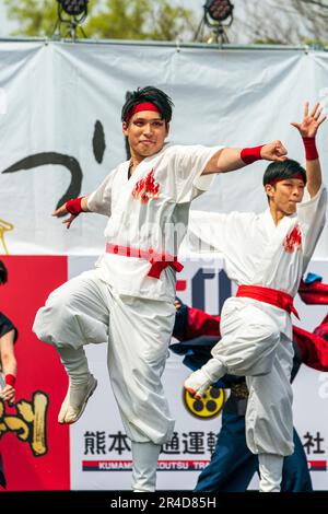 Giovani danzatori giapponesi Yosakoi che indossano yukata bianca e pantaloni con sashes rosso, sul palco dell'annuale festival di danza Kyusyu Gassai a Kumamoto. Foto Stock