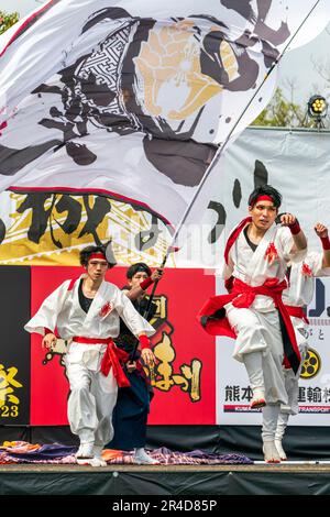 Giovani danzatori giapponesi Yosakoi che indossano yukata bianca e pantaloni con sashes rosso, sul palco dell'annuale festival di danza Kyusyu Gassai a Kumamoto. Foto Stock