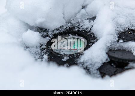 Il termometro sul coperchio di un contenitore di compost coperto di neve in inverno mostra che il contenuto del contenitore è freddo, Cambridge, UK. Foto Stock