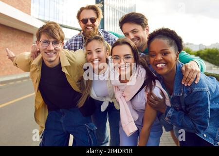 Gruppo felice multietnico giovani uomo e donna con il sorriso in posa durante le passeggiate in città Foto Stock
