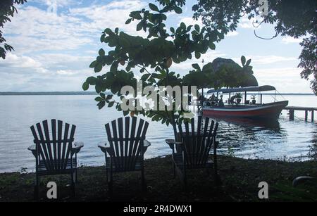 Vista dal molo e dal rifugio palapa sul bellissimo lago Peten Itza, El Remate, Petén, Guatemala Foto Stock