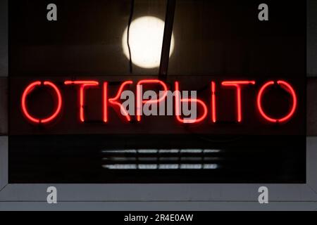 Luce rossa al neon modellata nella parola russa che significa 'APERTO' in inglese. Foto Stock