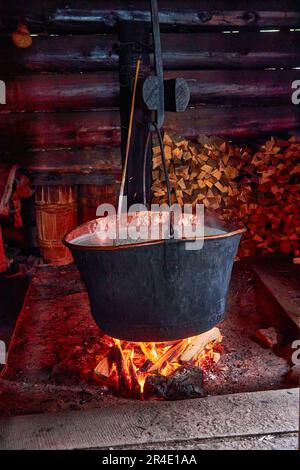 Produzione di formaggio di pecora biologico in montagna lignea fabbrica di formaggio carpazi con un calderone fumato bollente con latte a fuoco aperto, Ucraina occidentale, Europ Foto Stock