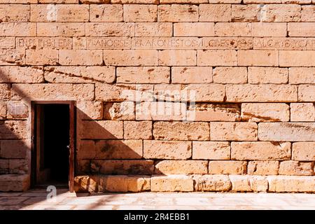 Iscrizioni sul muro di pietra. Gli Aljibes de las Peñuelas sono un complesso monumentale situato in Plaza de la Maestranza, a Melilla la Vieja, nel centro termale Foto Stock