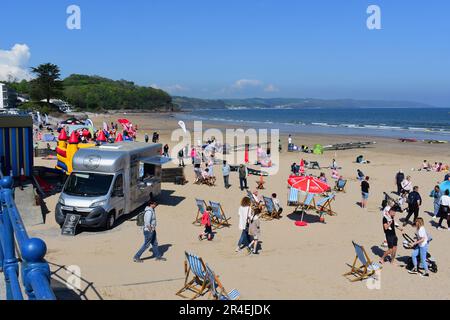 Una tipica e affollata scena turistica britannica sulla spiaggia in estate a Saundersfoot nel Galles del Sud. Le famiglie si divertano a sedersi e a giocare sulla sabbia. Foto Stock