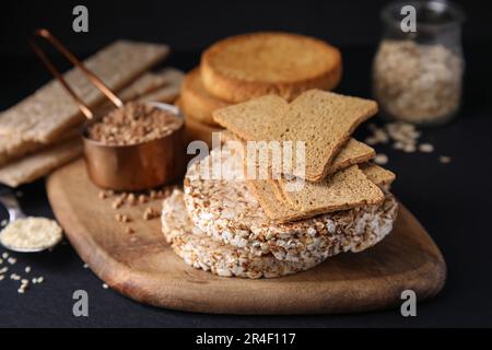 Crostini di segale, torte di riso e fette biscottate sul tavolo nero Foto Stock