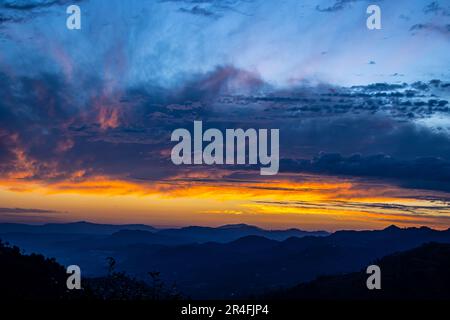 tramonto di montagna con cielo nuvoloso Foto Stock