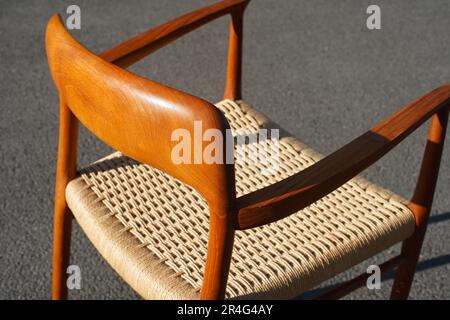 Una moderna poltrona danese in teak della metà del secolo d'epoca del 60s in piedi nel soggiorno da pranzo con sedile in legno teak con cordino di carta originale 50s 70s retro Foto Stock