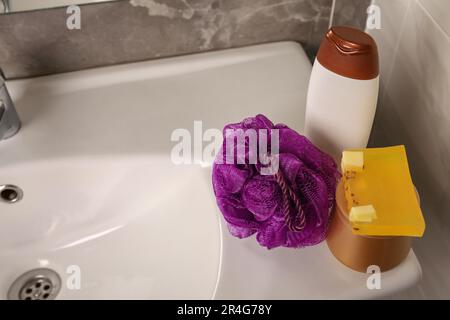 Soffio doccia viola e prodotti cosmetici sul lavandino in bagno, spazio per il testo Foto Stock