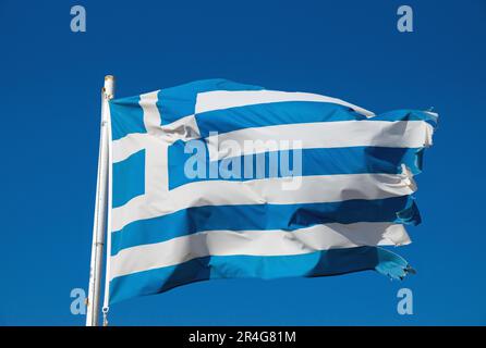 Una bandiera nazionale greca leggermente lacerata che sventola nel vento Foto Stock