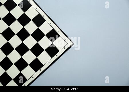 Scacchiera vuota in bianco e nero su sfondo grigio chiaro, vista dall'alto. Spazio per il testo Foto Stock