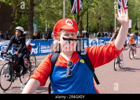 Westminster, Londra, Regno Unito. 28th maggio, 2023. Nell'ambito dell'evento ciclistico RideLondon di tre giorni, un ampio percorso intorno al centro di Londra è stato chiuso al traffico per consentire ai membri del pubblico di superare i monumenti storici della città senza altri veicoli, tra cui il passaggio di Buckingham Palace e il centro commerciale. Cavaliere in costume Super Mario Foto Stock