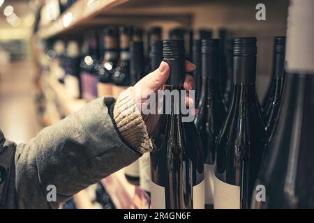 Donna che sceglie il vino nel mercato per il VIN brulé di capanno invernale Foto Stock