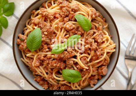 Pomodoro fatto in casa basilico salsiccia Spaghetti in una ciotola, vista dall'alto. Giacitura piana, sovratesta, dall'alto. Primo piano. Foto Stock