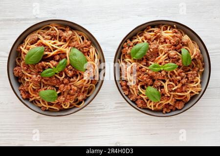 Pomodoro fatto in casa basilico salsiccia Spaghetti in ciotole, vista dall'alto. Giacitura piana, sovratesta, dall'alto. Foto Stock