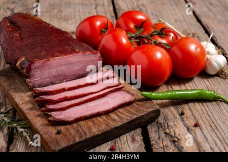 Tagliere con carne secca, verdure e spezie su un tavolo di legno. Messa a fuoco selettiva. Foto Stock