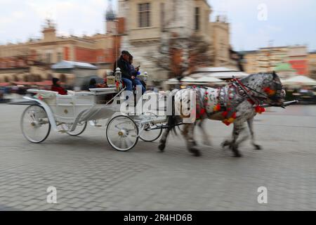 Immagine sfocata del movimento di un carrello trainato da cavalli. Cracovia, Polonia, Europa. Foto Stock