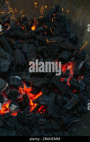 Carboni con scintille in un enorme sfondo di metallo vecchio grill Foto Stock