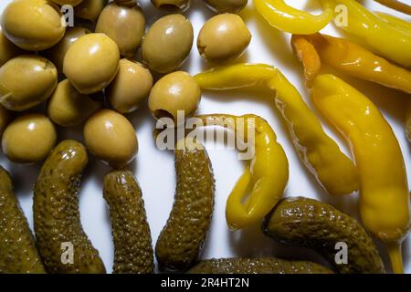 Primo piano di olive, sottaceti e peperoni caldi su un piatto bianco Foto Stock