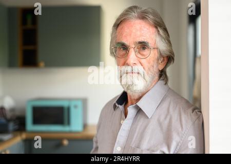 Uomo anziano felice con gli occhiali che guardano il ritratto della macchina fotografica Foto Stock