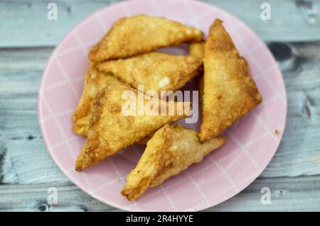 Una samosa Singara, una pasta fritta dell'Asia del Sud con un ripieno saporito che include ingredienti come patate speziate, cipolle, piselli, carne o pesce, sambousek Foto Stock