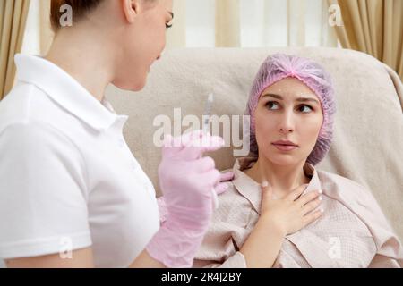 Il cosmetologo esegue la procedura di sollevamento iniettando le iniezioni di bellezza. Medico che inietta l'acido ialuronico come trattamento di ringiovanimento facciale Foto Stock