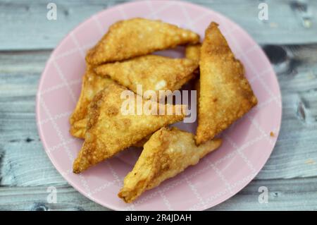 Una samosa Singara, una pasta fritta dell'Asia del Sud con un ripieno saporito che include ingredienti come patate speziate, cipolle, piselli, carne o pesce, sambousek Foto Stock