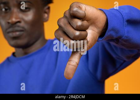 Triste deluso afro americano giovane che mostra pollice giù Foto Stock