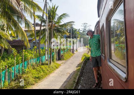 Turista godendo di un viaggio in treno da Ella a Kandy tra le piantagioni di tè nelle Highlands dello Sri Lanka Foto Stock