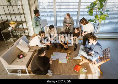 Vista ad alto angolo di imprenditori multirazziali maschili e femminili che discutono la strategia di affari nell'incontro all'ufficio creativo Foto Stock