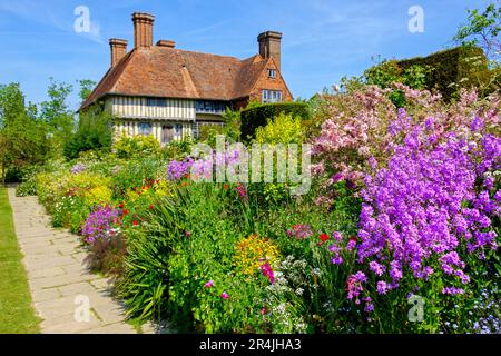 Grande casa e giardino dei Dixter, lungo confine colorato in primavera, East Sussex, Regno Unito Foto Stock