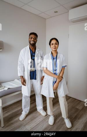 Ritratto di operatori sanitari sicuri di sesso maschile e femminile in piedi nella sala di consulenza Foto Stock