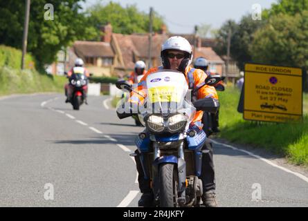 RideLondon Classique 2023 fase 2 passa attraverso il villaggio di Layer-de-la-Haye vicino a Colchester in Essex. Moto di sicurezza NEG su un percorso ciclistico Foto Stock