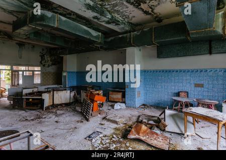 Cucina abbandonata e rovinata di mensa o ristorante di fabbrica chiuso. Foto Stock