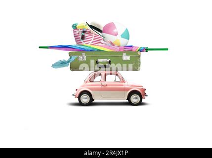 Auto rosa retrò con bagagli e attrezzature da spiaggia sul tetto Foto Stock